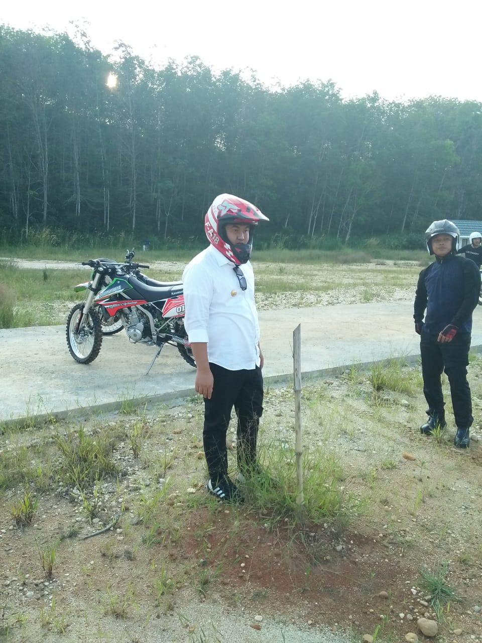 Bupati Dharmasraya Sutan Riska menggunakan motor untuk menempun lokasi bekas penambangan liar.