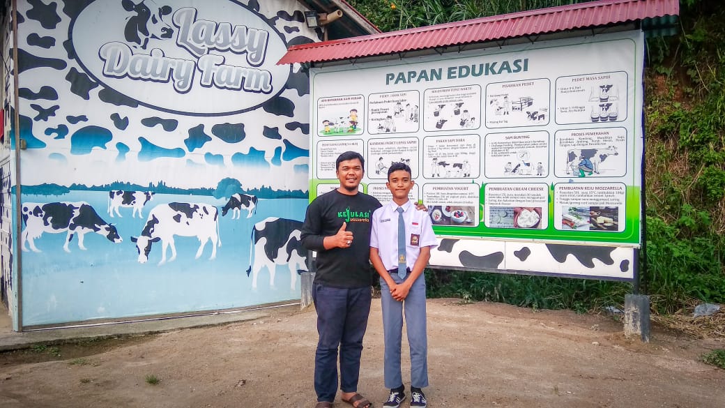 Suhatril bersama salah seorang siswa pengunjung Sentra sapi perah miliknya
