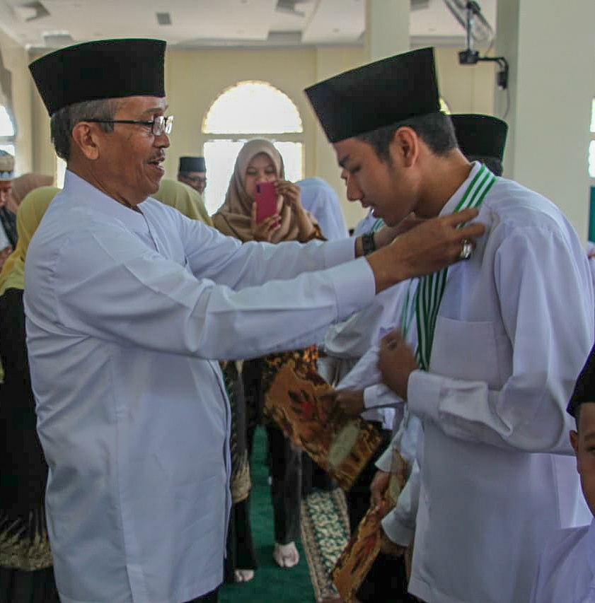 Bupati Solok Gusmal mengalungkan medali kepada salah seorang peserta tahfidz Alquran