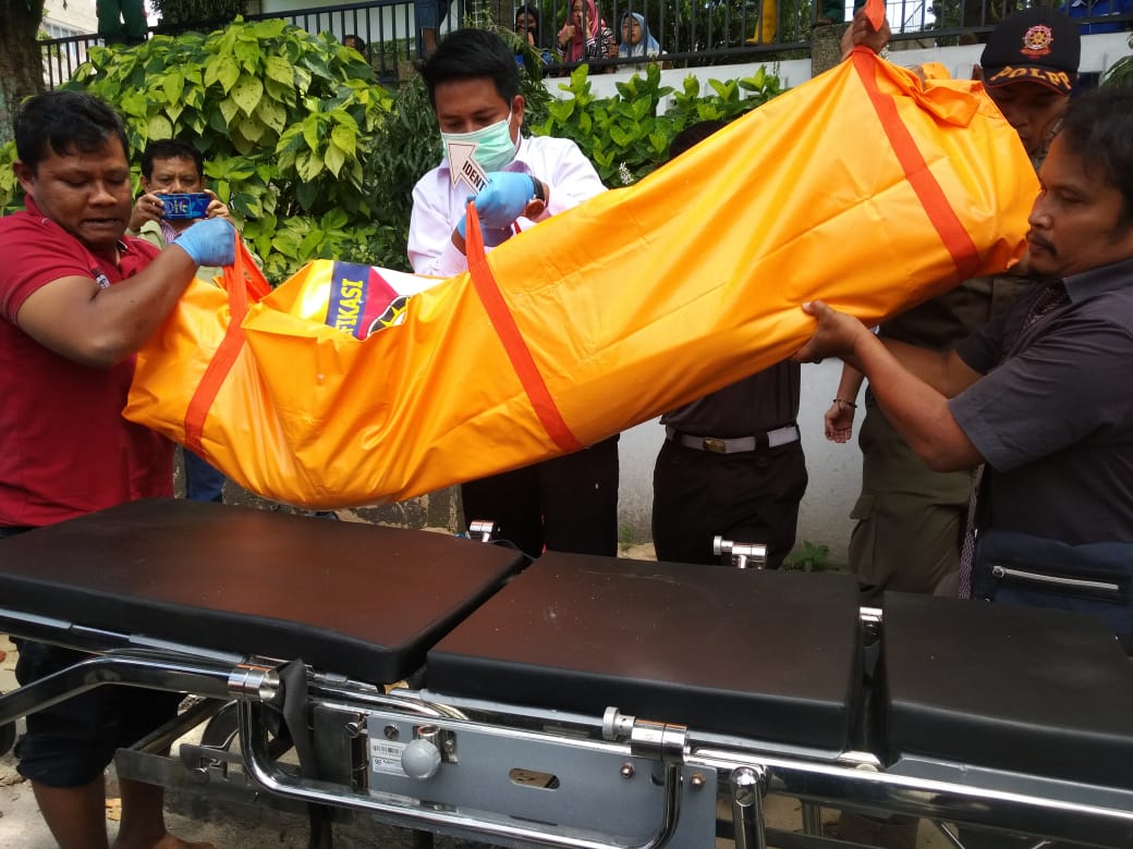 Petugas polisi melakukan evakuasi mayat yang ditemukan dalam saluran air di jalan Agus Salim kota Bukittinggi, Senin (9/9/2019). 