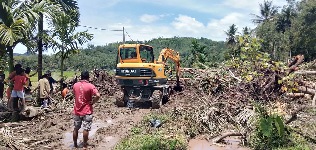 Alat berat  sedang membersihkan material longsor yang menimpa rumah warga di sejumlah titik di Kecamatan Bayang, Sabtu (15/2).