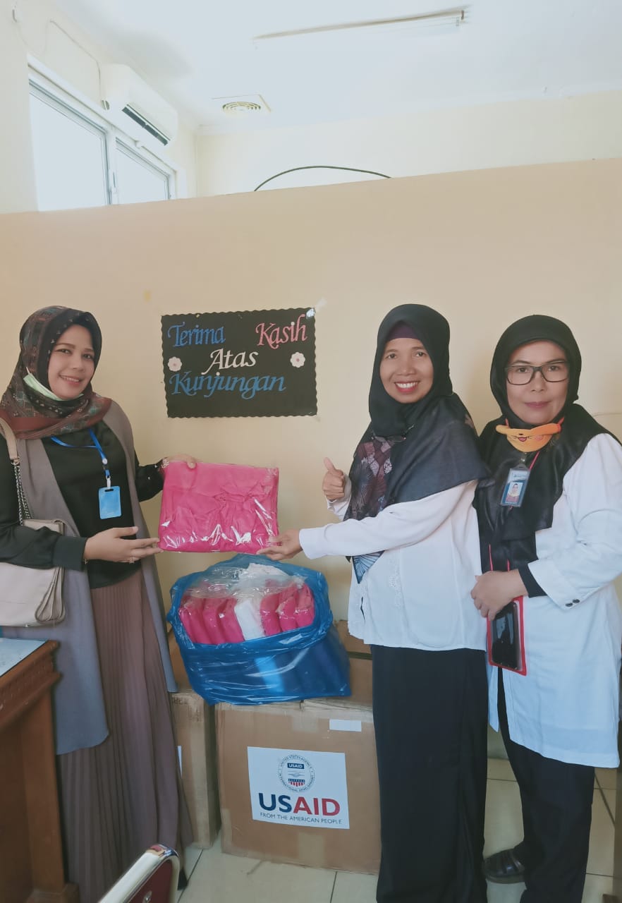 Ade Hilma Sari (kiri) menyerahkan bantuan, diterima Irfanida Maya (tengah)