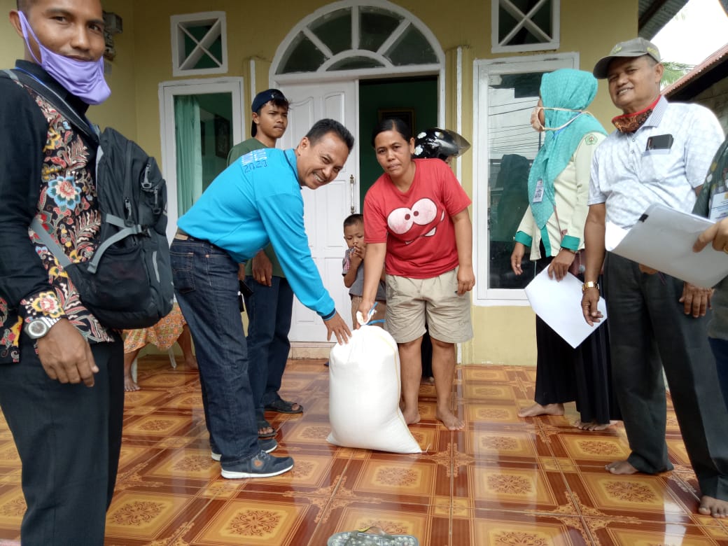 Lurah Simpang Rumbio Zulkifli Uwan ketika menyerahkan bantuan