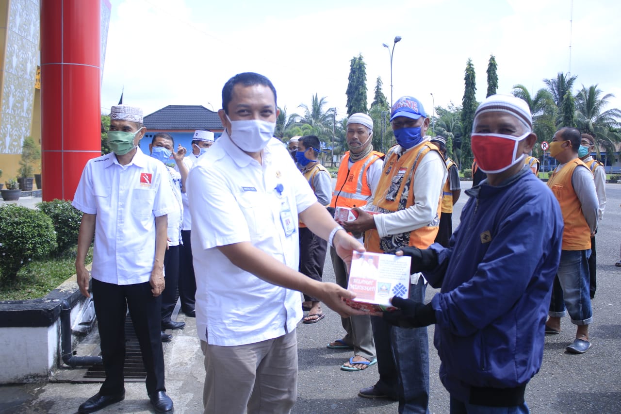 Kadis Transmigrasi dan Tenaga Kerja Kabupaten Dharmasraya Marten Yunus. M. ENg, bagikan makan gratis kepada tukang Ojek, dan petugas kebersihan lingkungan.