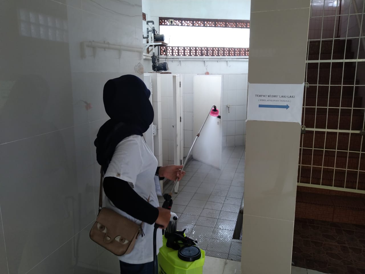 Penyemprotan masjid dan mahasiswa oleh mahasiswa KKN UNP 2020