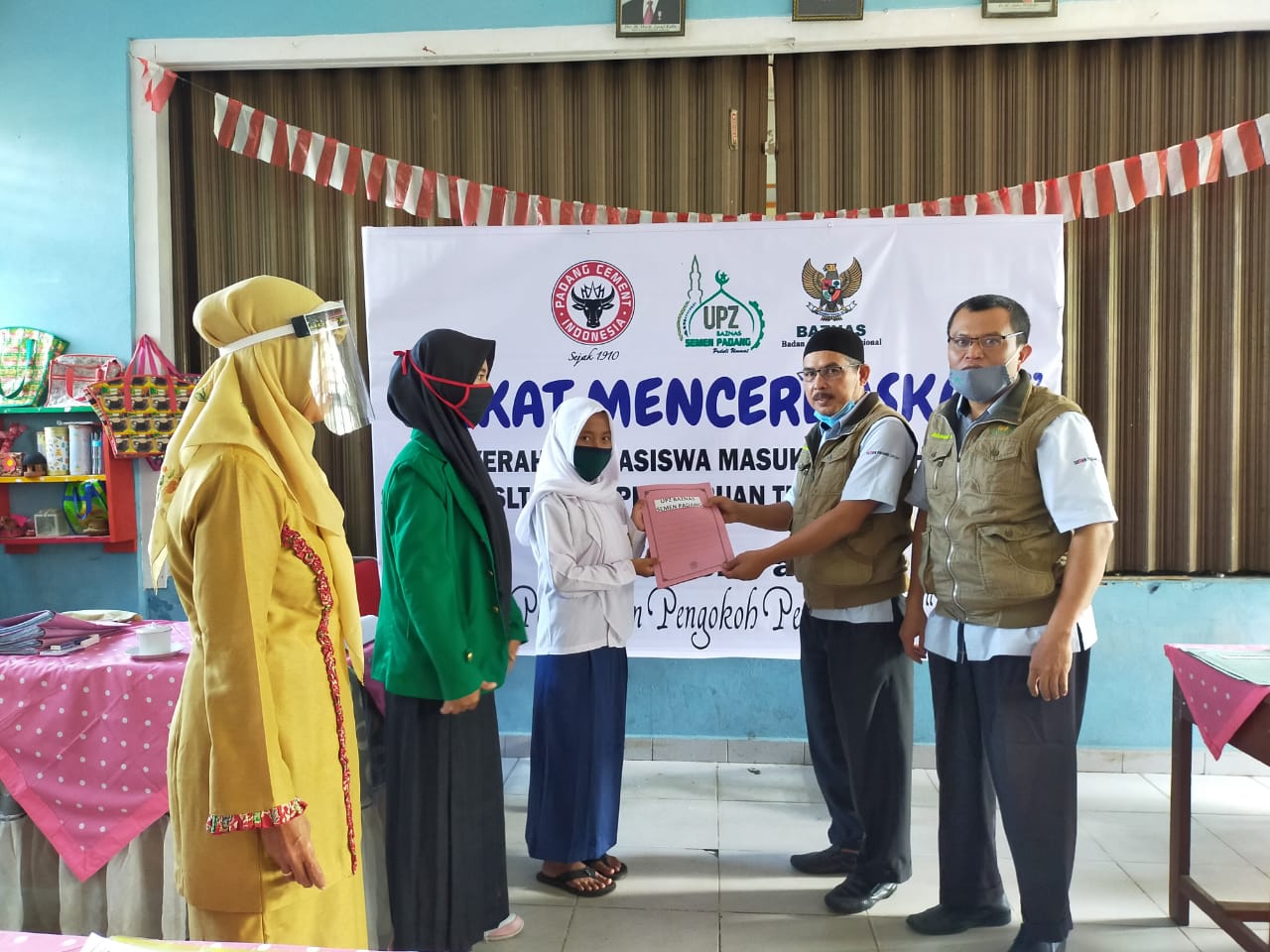 Kepala Pelaksana Harian UPZ Baznas Semen Padang Muhammad Arif menyerahkan bantuan kepada salah seorang pelajar di  SD 13 Batu Gadang
