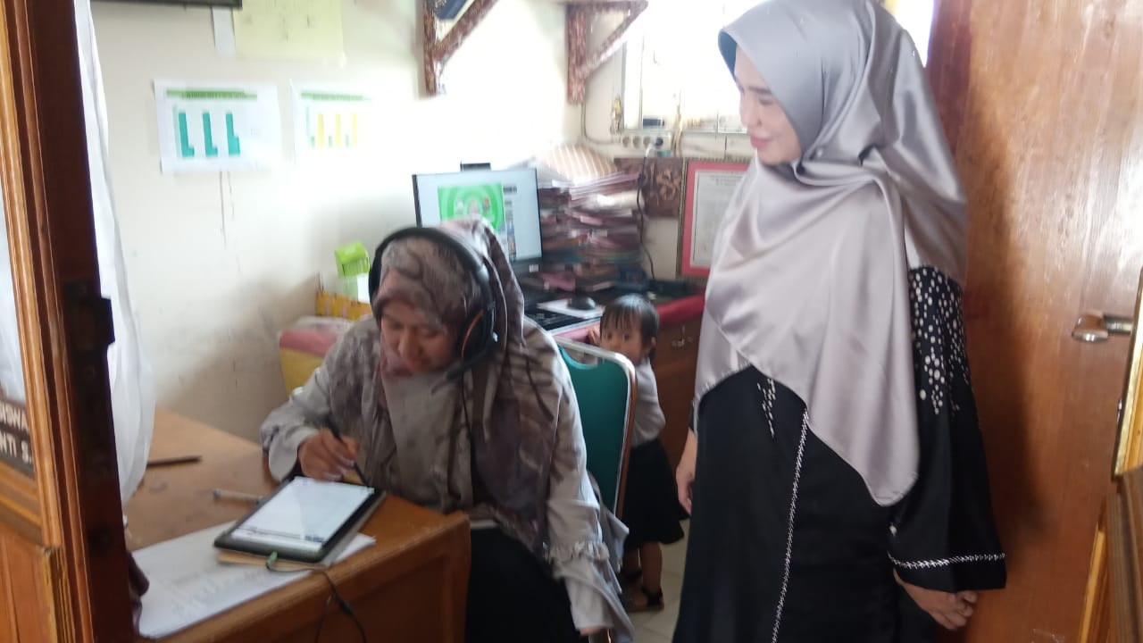 Salah seorang guru SMAN5 Solok Selatan memberikan pelajaran melalui Tablet disaksikan kepala sekolah
