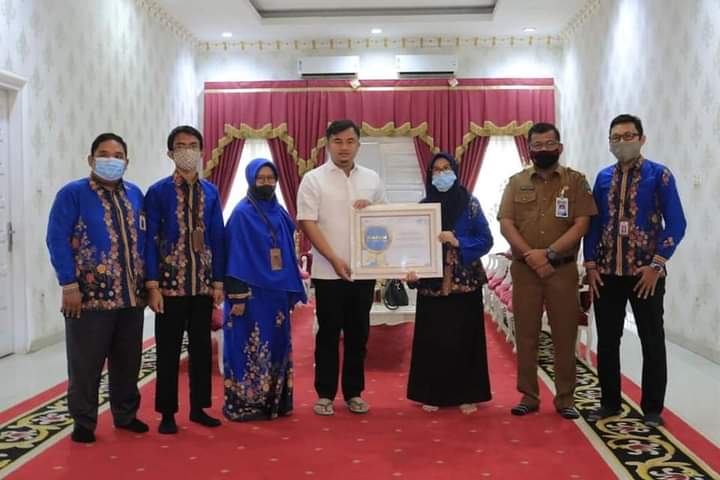 Bupati Dharmasraya saat menerima penghargaan dari BPS