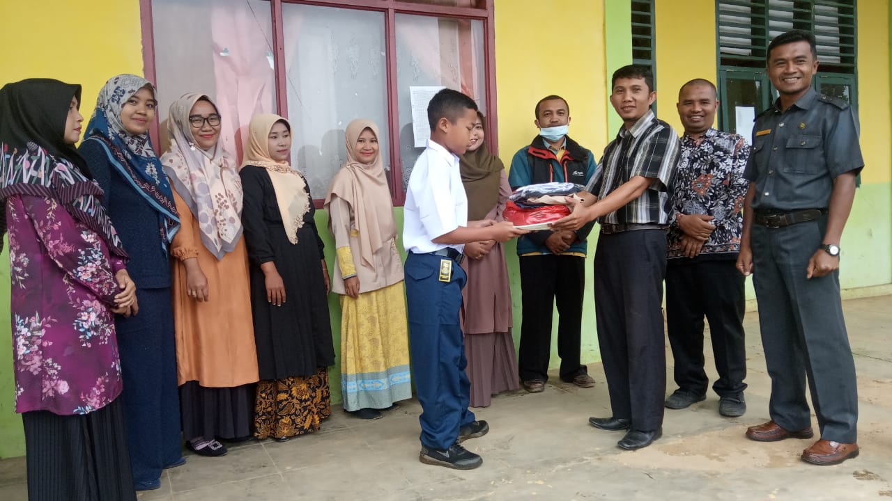 Pirdaus, siswa kelas VIII MTsS Darul Ulyah Pekonina Solsel saat menerima bantuan pakaian dari guru honorer di madrasah tersebut