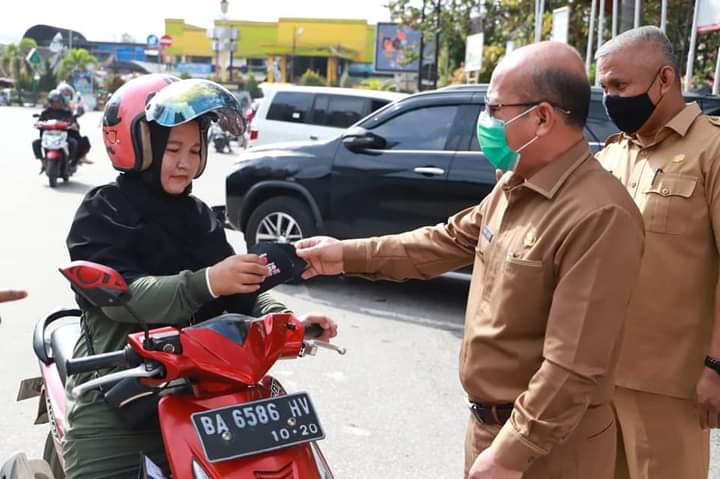 Pjs Walikota Solok Asben Hendri didampingi Kakan Kesbangpol Fidlywendi Alwi menyerahkan masker