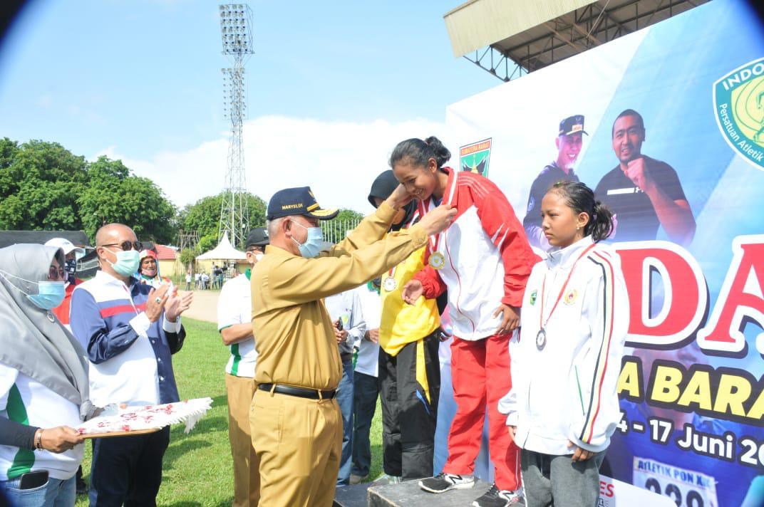 Gubernur Sumbar, Mahyeldi, mengalungkan medali pada pemuncak lomba yang diadakan pada POPDA Sumbar, di GOR H Agus Salim Padang, Senin (14/6/2021).