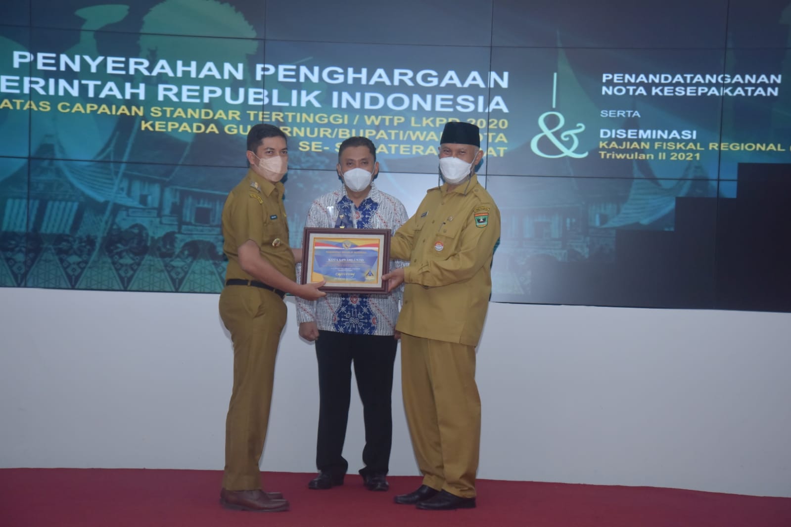 Walikota Deri Asta didampingi Gubernur Sumbar Mahyeldi Ansharullah menerima plakat dan piagam penghargaan yang diserahkan Kepala Kanwil Ditjen Perbendaharaan Sumbar, Heru Pudyo Nugroho, Senin 25 Oktober 2021 di Padang.