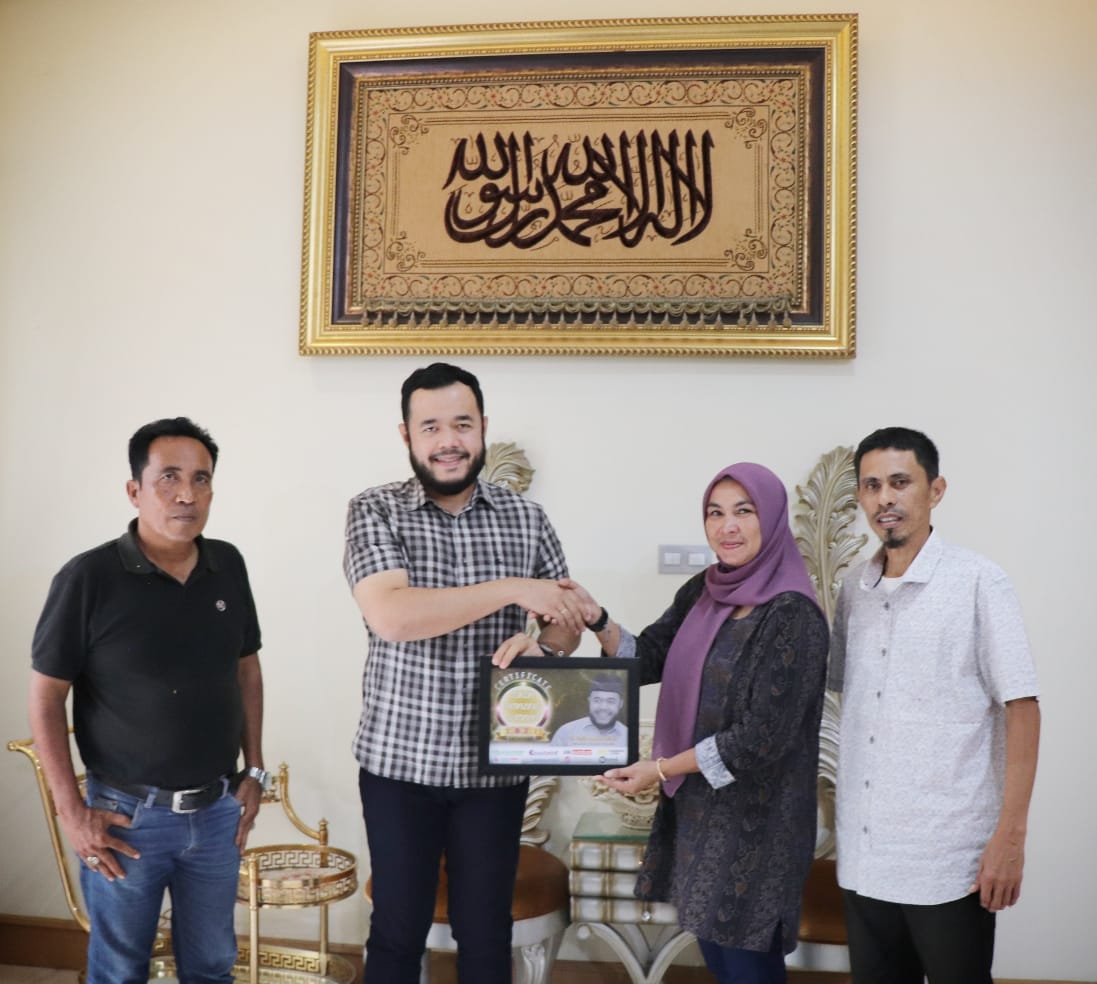 Owner www.tribunsumbar.com-Mona Sisca menyerahkan plakat Tokoh Amazing 2021 kepada Wali Kota Padang Panjang, Fadly Amran, Minggu (16/1/2022).
