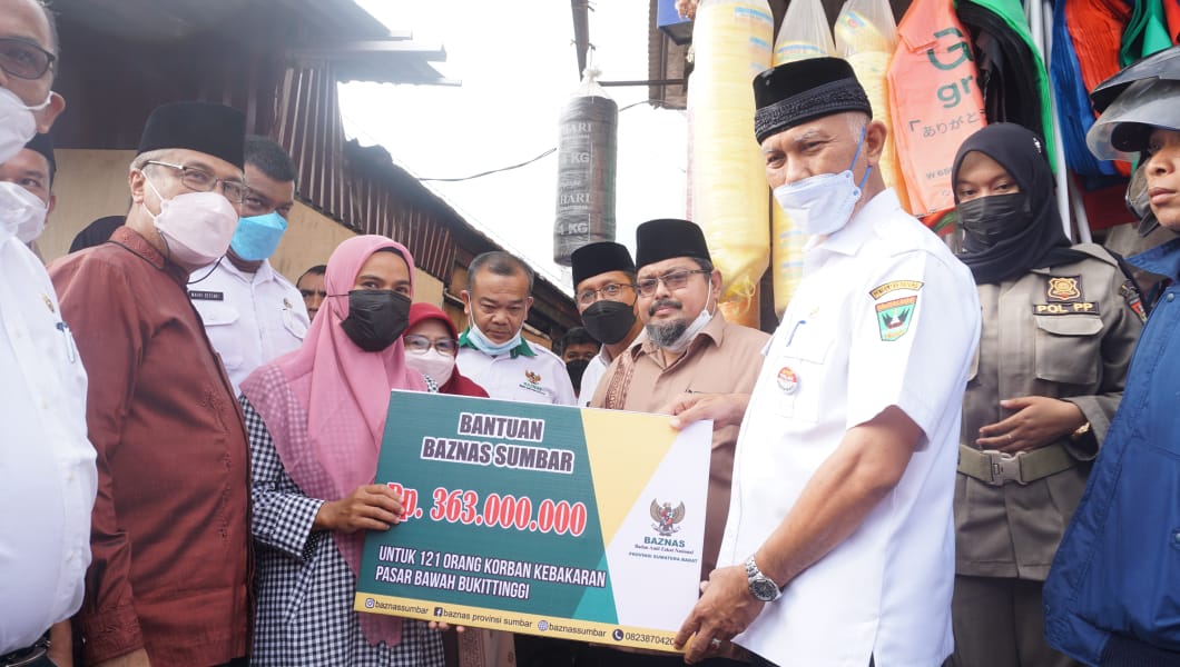 Gubernur Sumbar, Mahyeldi, menyerahkan secara simbolis bantuan kepada salah seorang pedagang, di Bukittinggi, Rabu (16/2/2022).