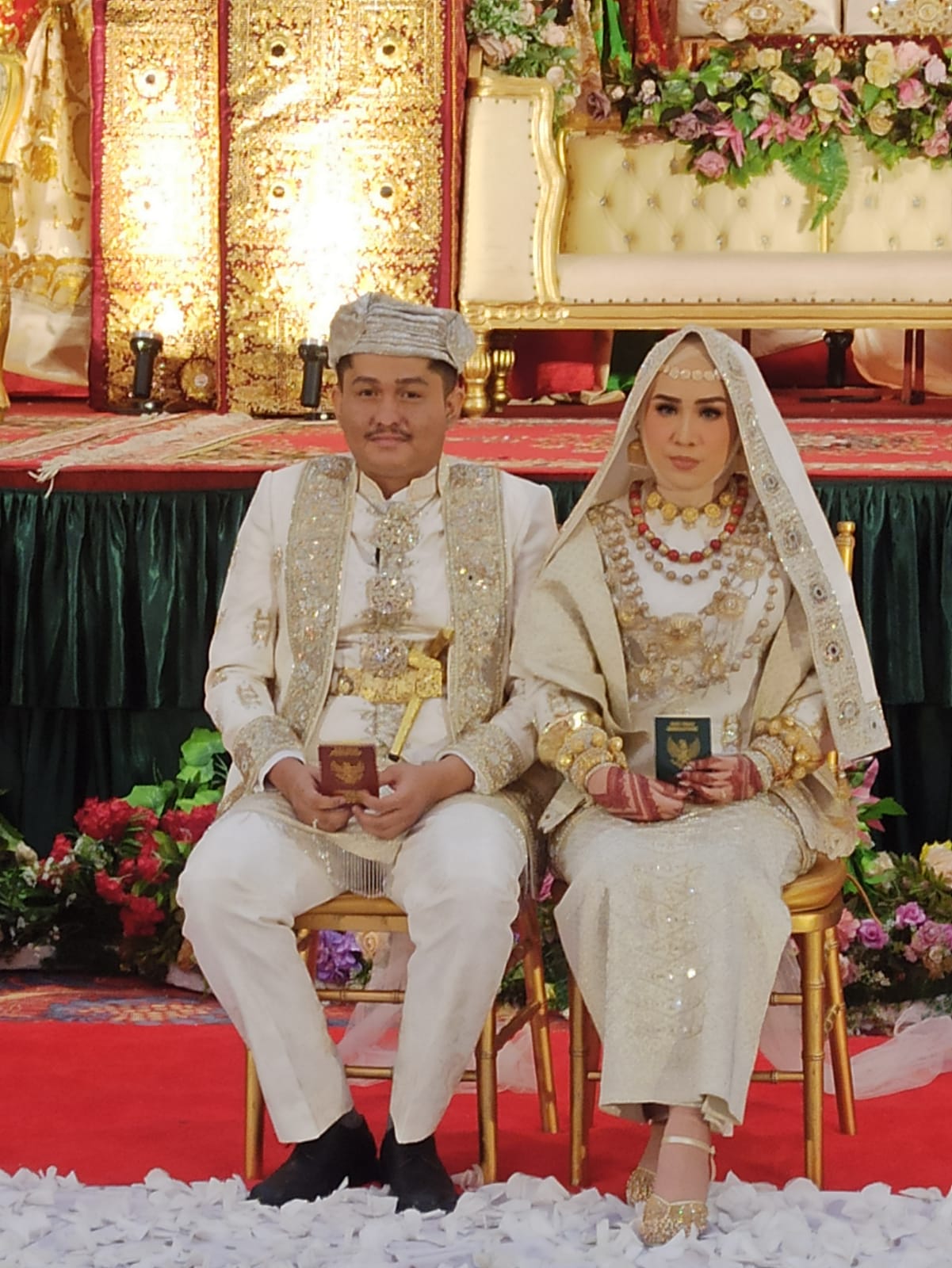 Pasangan Ikhwan dan Laras, memegang buku nikah masing-masing setelah prosesi akad nikah, Sabtu (21/1/2023) di UPI Exhibition & Hall Padang.