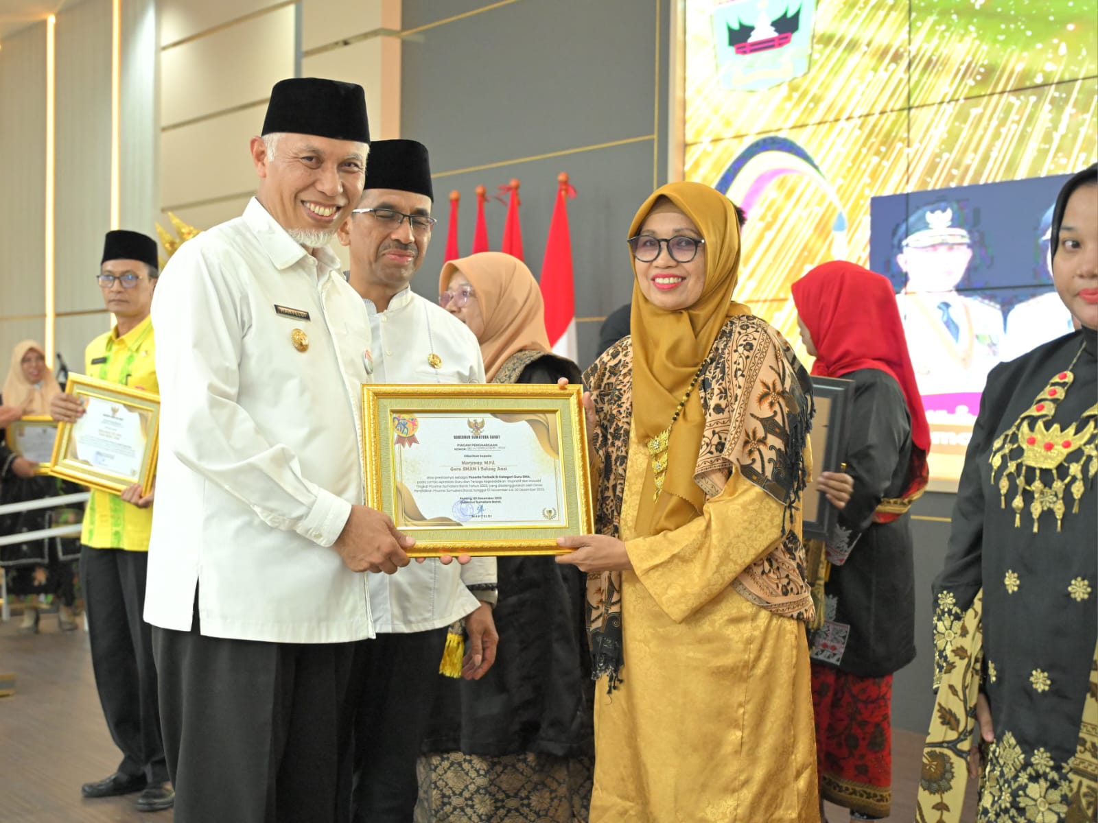 Gubernur Mahyeldi menyerahkan penghargaan Apresiasi Guru dan Tenaga Kependidikan (GTK) Berprestasi Provinsi Sumatera Barat tahun 2023, di Padang, Jumat (8/12/2023). Foto Adpsb. 