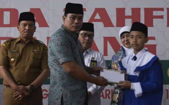  Ketua DPRD Mardiansyah, saat serahkan piagam pada salah seorang peserta wisuda tahfiz MTsN Kota Padang Panjang, Senin (26/2/2024) siang.