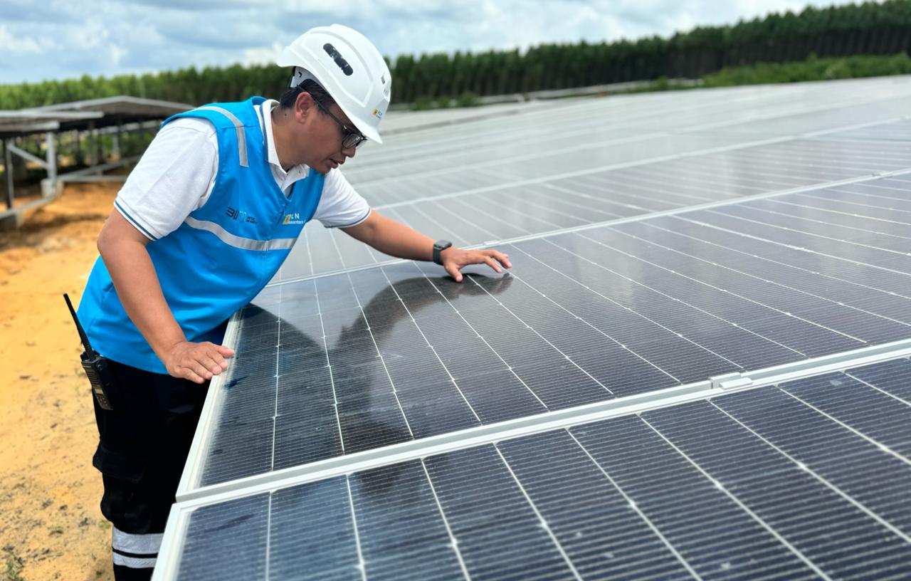 Petugas PLN Nusantara Power mengecek panel surya di PLTS IKN.