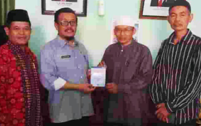 Kakan Kemenag Alizar Chan saat serahkan bantuan dari Kemenag RI  pada Ketua Pengurus Masjid Jami, Ustad Ade Sehabudin, Kamis (14/3/2024) kemaren diruang kerjanya.