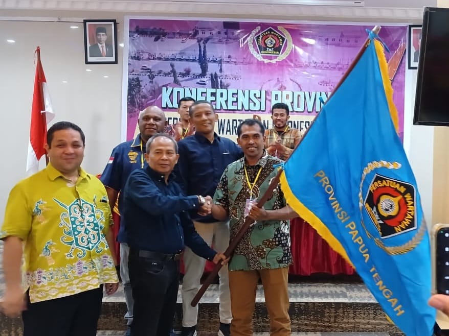 Wakil Sekjen PWI Pusat, Raja Parlindungan Pane menyerahkan bendera PWI kepada Lambert "Bams" yang dipercayakan menahkodai Persatuan Wartawan Indonesia (PWI) Papua Tengah periode 2024-2029. Foto dok Pwi.