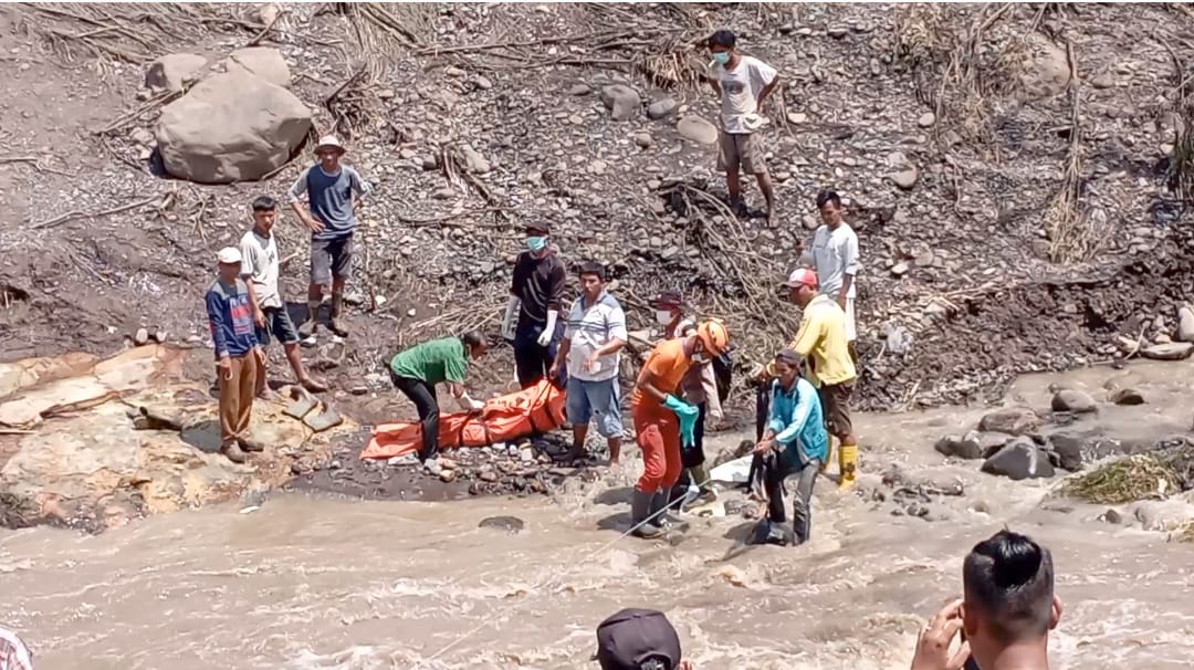 Bripka Ciko Bersama Wali Nagari Baringin dan masyarakat mengevakuasi potongan tubuh korban banjir bandang.