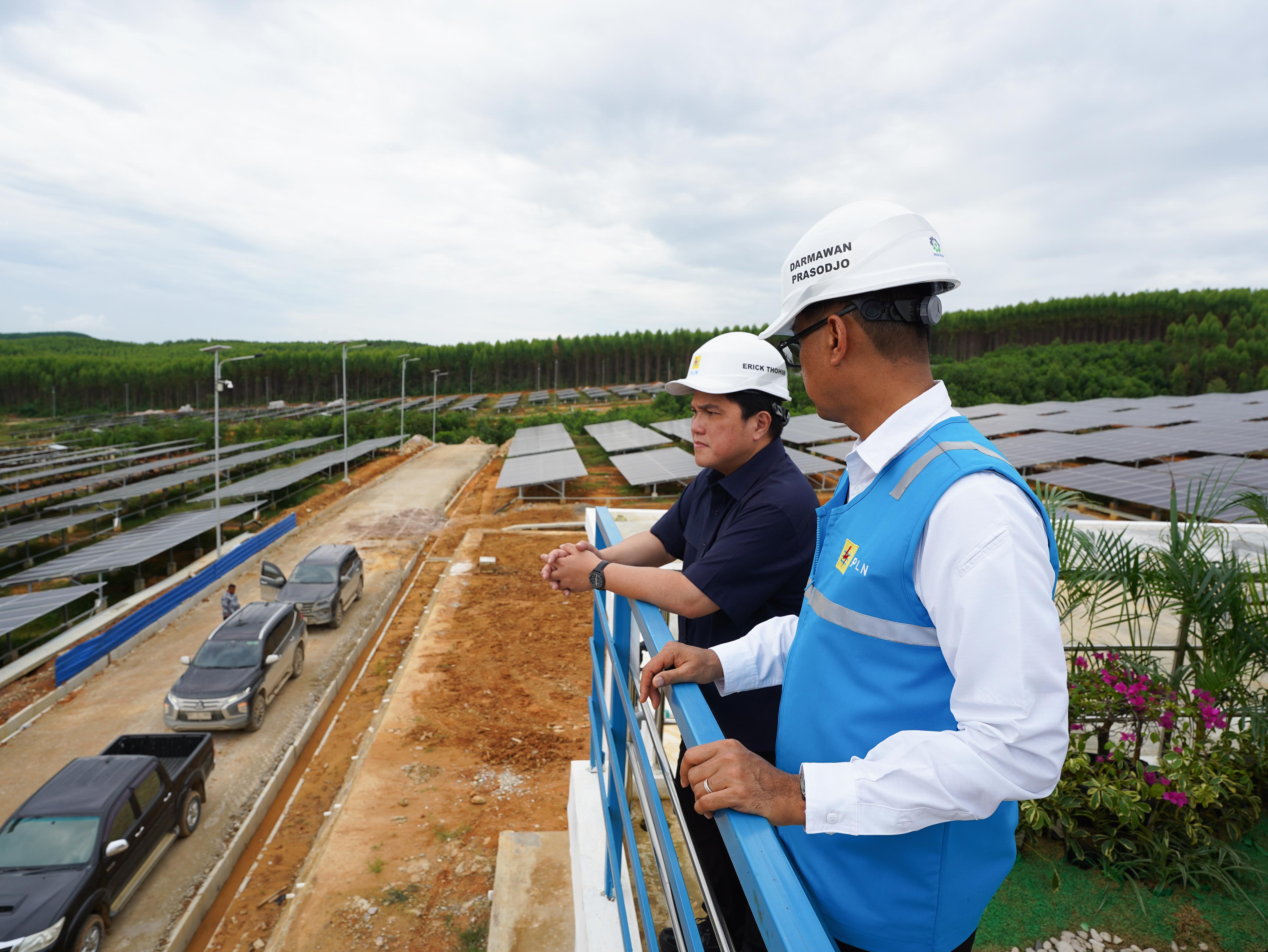 Menteri BUMN Erick Thohir (kiri) bersama Direktur Utama PLN Darmawan Prasodjo (kanan) saat meninjau pembangkit listrik tenaga surya (PLTS) Ibu Kota Nusantara, di Penajam Paser Utara, Kalimantan Timur, Sabtu (29/6).