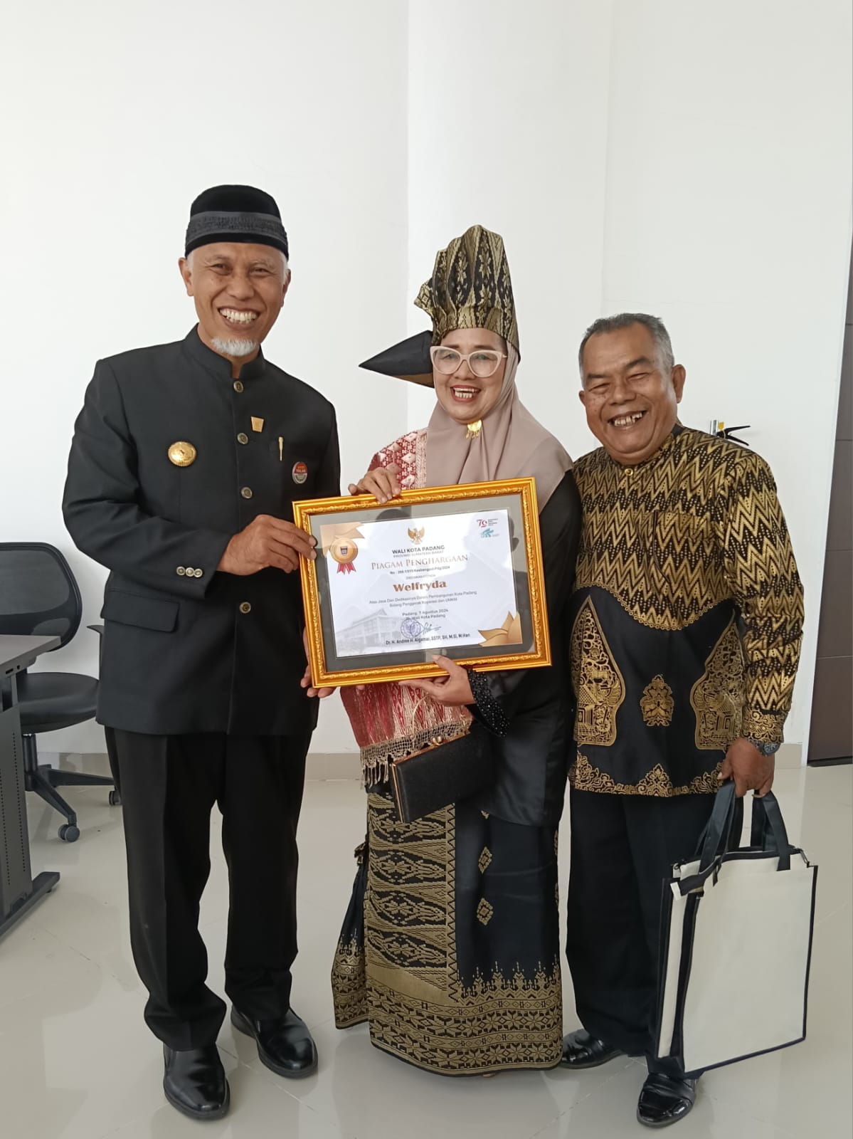 Penerima pin emas Ny. Welfrydha, tokoh wanita pelaku UMKM, bersama Gubernur Sumbar Mahyeldi, dan suaminya Nofi Sastra, pemred majalahintrust.com. Foto Nns.