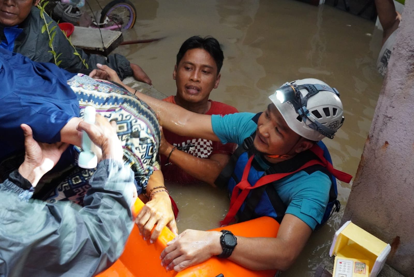 Petugas PLN membantu proses evakuasi korban bencana banjir ke tempat yang lebih aman di Kecamatan Jatiasih, Bekasi.