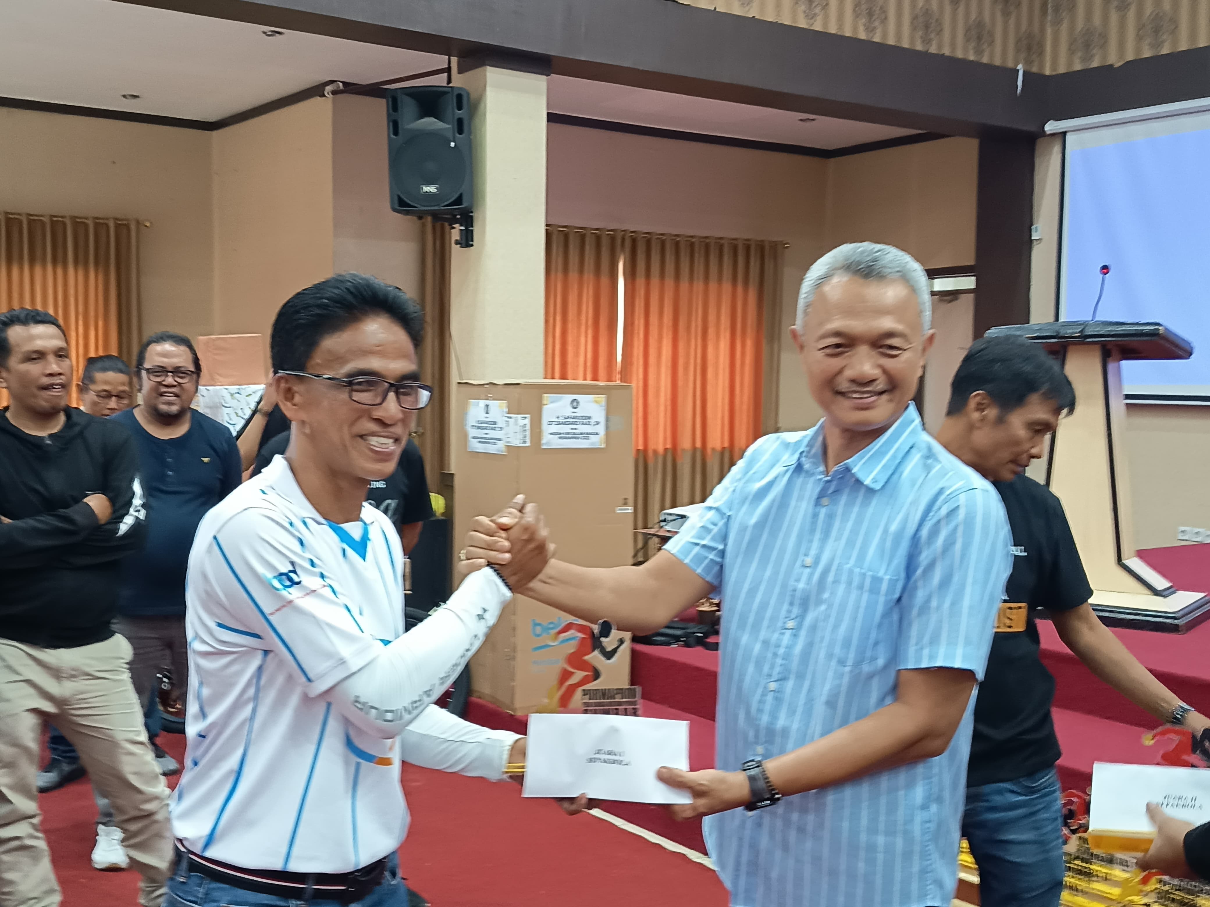 Direktur Operasional Bank Nagari, Zilfa Efrizon menyerahkan hadiah pemenang cabang sepakbola porwaprov kepada kapten Bank Nagari Fc, Tasman