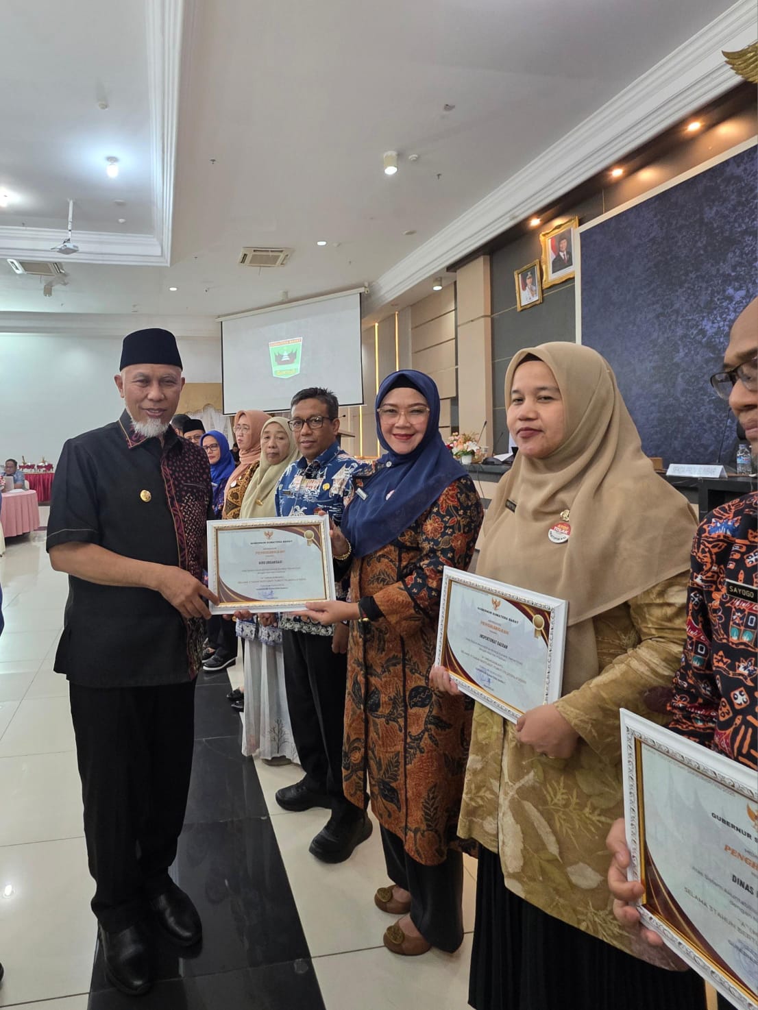 Penyerahan penghargaan oleh Gubernur Sumbar Mahyeldi kepada Kepala Biro Organisasi, Dina Febriyanti. 