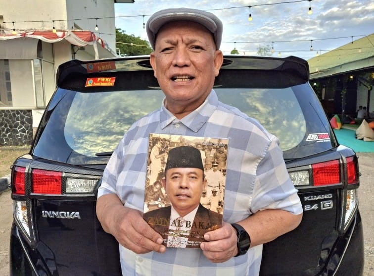 Ketua PWRI Sumbar, Syafzal Ucok, MM., dengan buku otobiografi mantan Gubernur Sumbar, H. Zainal Bakar, SH. Foto Gk.
