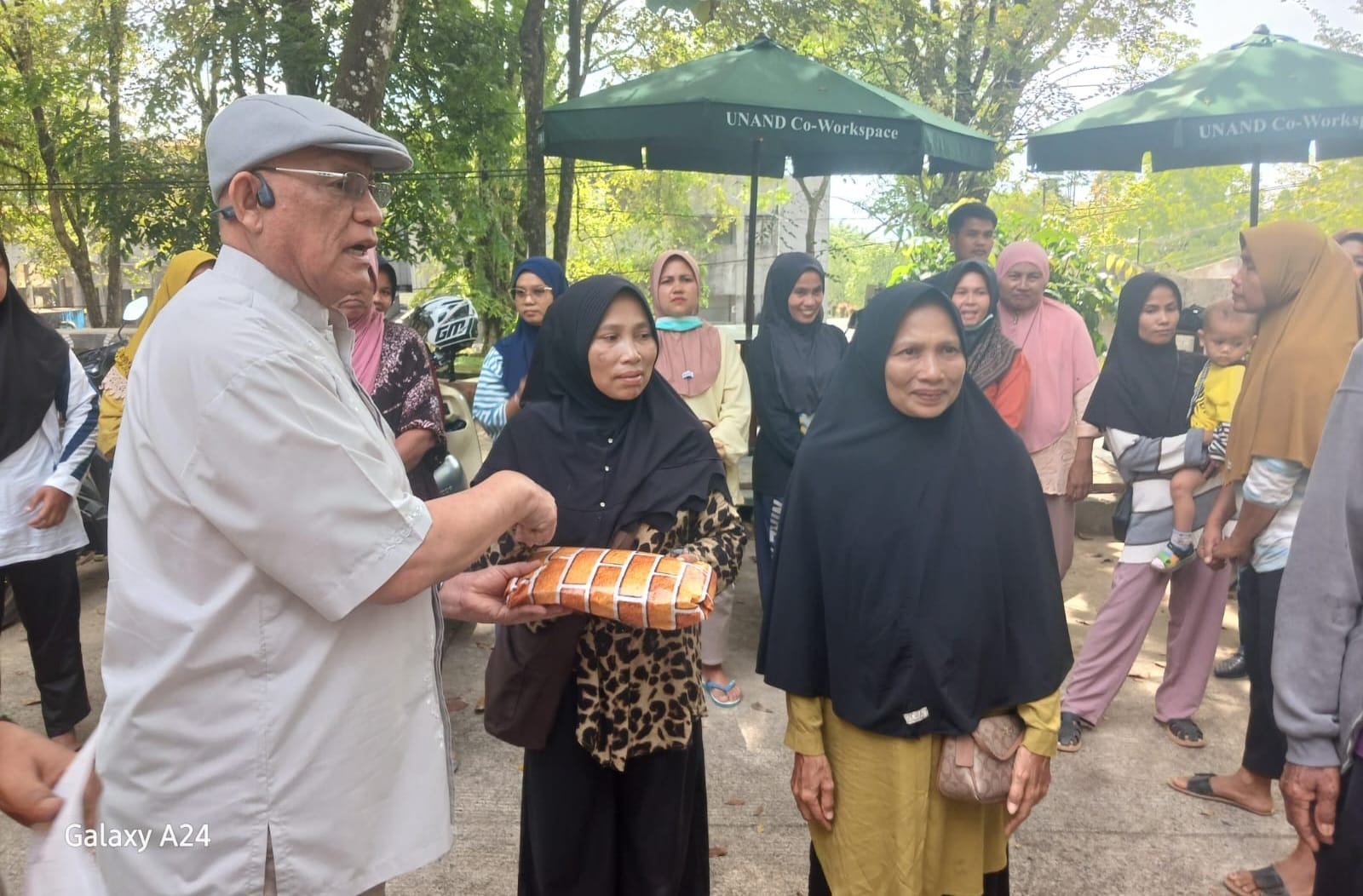 Ketua PWRI Sumbar Syafrizal Ucok menyerahkan bantuan pakaian baru, uang tunai dan madu lebah untuk warga terdampak banjir bandang di Batu Busuak, Kecamatan Pauh, Kota Padang, Jumat (16/1/2026). Foto Gk.