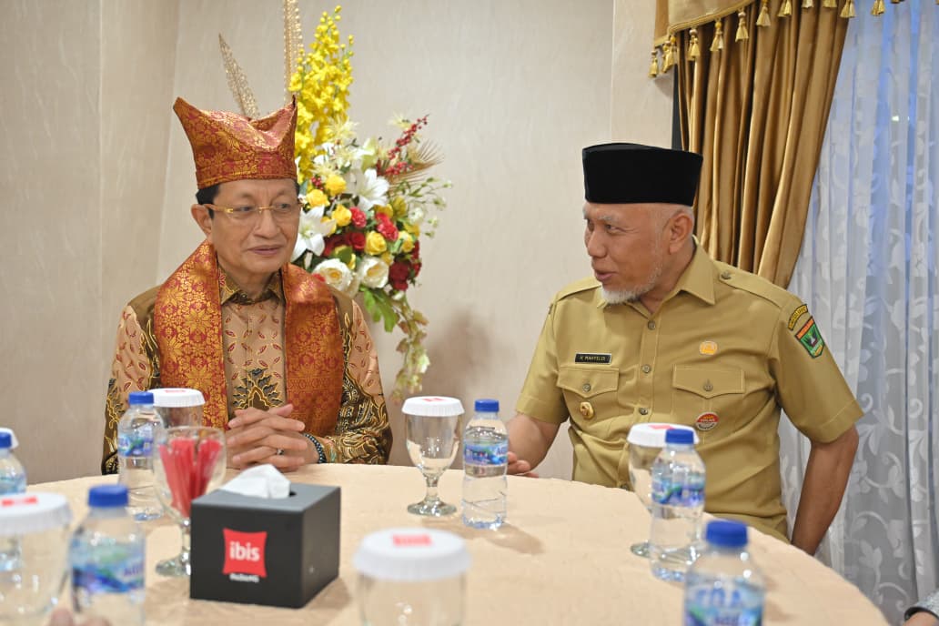 Menteri Agama, Nasaruddin Umar (kiri) dengan memakai Deta dan Sal khas Minang yang dipasangkan oleh Gubernur Sumbar Mahyeldi. Foto Adpsb. 