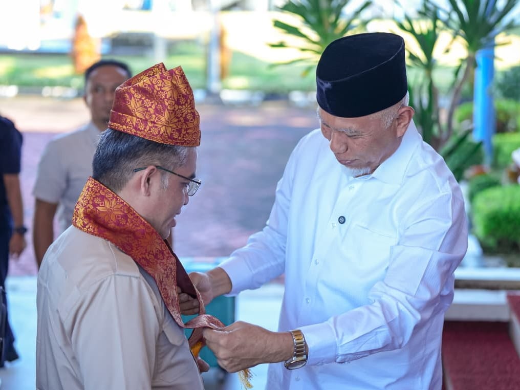 Gubernur Sumbar memasangkan deta dan syal khas Minang kepada Menteri Ketenagakerjaan, Yassierli di VIP Bandara Internasional Minangkabau (BIM) Kamis (14/5/2026). Foto Adpsb. 