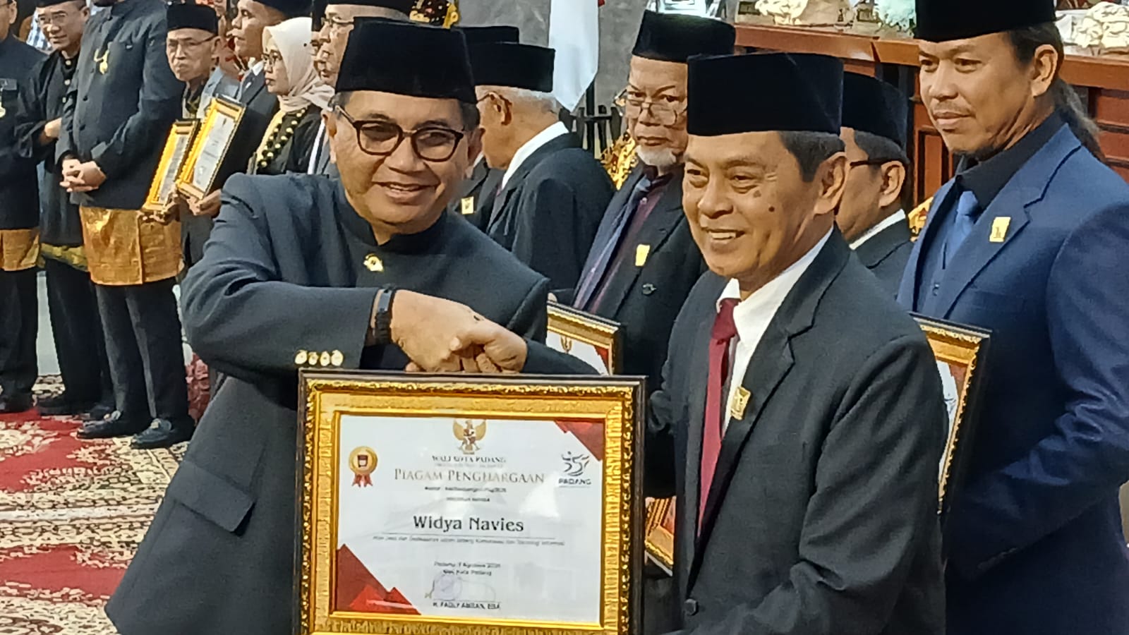 Ketua PWI Sumbar, Widya Navies saat menerima pin emas dan Piagam Penghargaan 