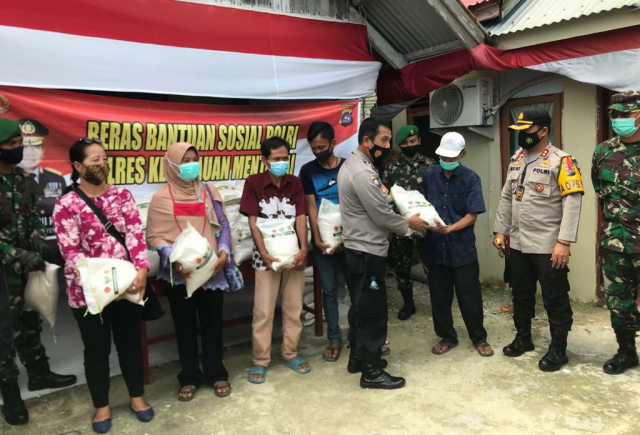 Kapolres Mentawai bersama Dandim Mentawai dan masyarakat penerima bantuan.