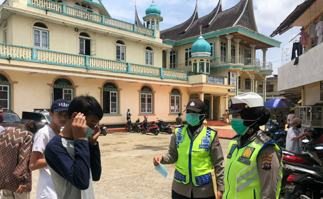 Polwan Polres Bukittinggi saat membagikan masker kepada masyarakat.