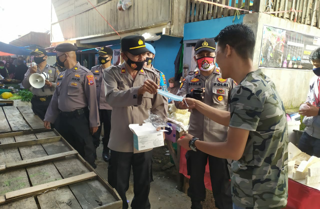 Kapolsek IV Koto bersama anggota saat bagi-bagi masker.