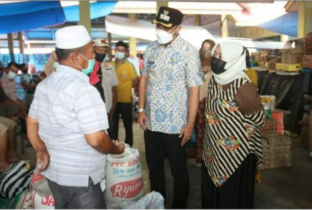 Bupati Sijunung, didampingi Ketua TP PKK, sedang bincang bincang dengan salah seorang pedagang