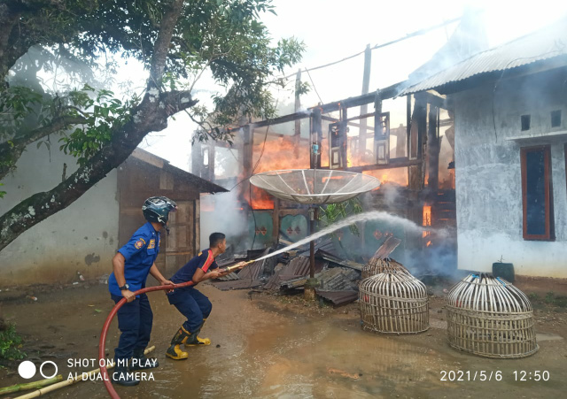 Petugas Damkar berusaha memadamkan api