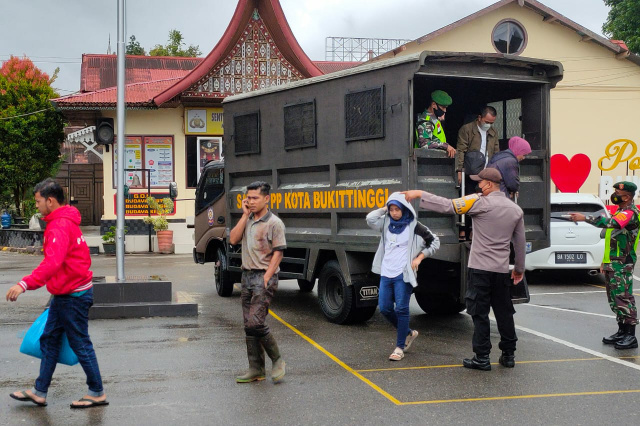 Warga yang terjaring operasi yustisi diangkut petugas untuk didata.