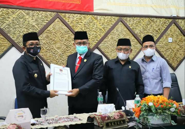 SERAHKAN - Ketua DPRD Padang Syafrial Kani menyerahkan persetujuan KUA PPAS APBD 2022 kepada Walikota Padang Hendri Septa.