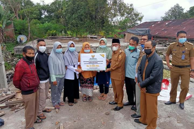 Bupati Tanah Datar Eka Putra didampingi Ketua BAZ, Camat X Koto dan Wali Nagari Panyalaian Roni Dt Paduko Sirajo saat menyerahkan bantuan kepada warga Gantiang korban musibah lalin, Selasa (24/8) petang yang diterima langsung warga korban musibah.