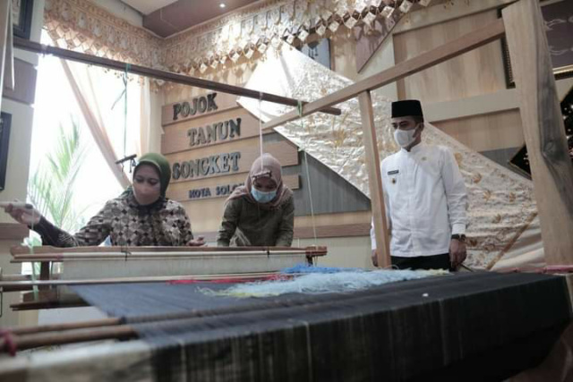 Bupati Inhu Rezita Meylani belajar menenun disaksikan Wakil Walikota Ramadhani.