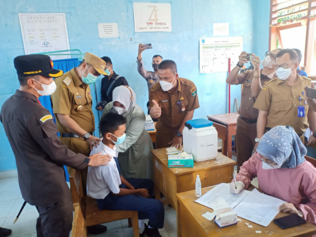 Kadis Kesehatan Sumbar, didampingi Bupati, Kajari dan Kadis Dikbud Sijunjung, sedang dialog dengan salah sorang siswa yang akan divaksin