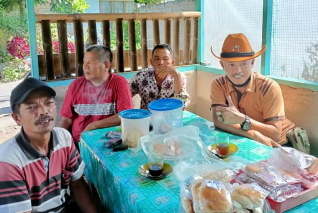 Lurah Ekor Lubuak Kecamatan Padang Panjang Timur, Emrie Enise saat bertukar pikiran dengan warganya d iwarung kopi, Minggu (26/9/21) pagi.