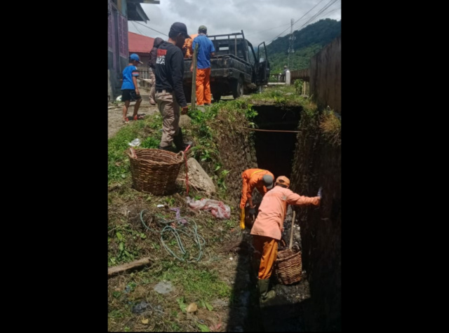 Petugas Dinas Perkim LH Padang Panjang, terlihat saat membersihkan saluran drainase dari tumpukan sampah pasca hujan deras.