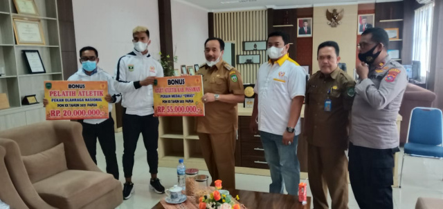 Bupati Pasaman, Benny Utama saat serahkan bonus medali emas PON Papua kepada Fauma Depril Jumra