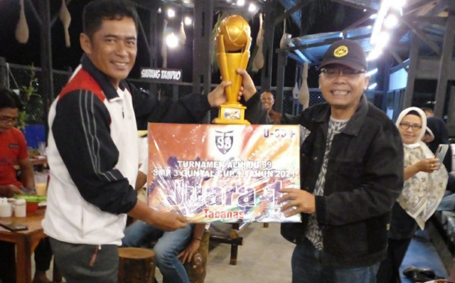 Coach Darwin Prawira menyerahkan trophy dan tabanas kepada Presiden Klub PS Symphony, TE, Minggu (21/11) malam, saat merayakan kemenangan tim di Memo Resto, Solok
