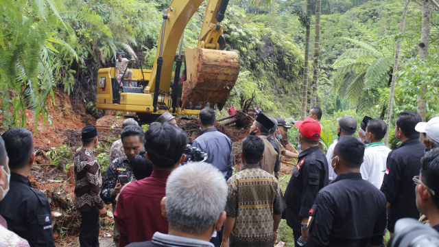 Bupati Solok Epyardi Asda menyaksikan pengoperasian excavator didampingi Camat Hiliran Gumanti Romi Hendrawan.